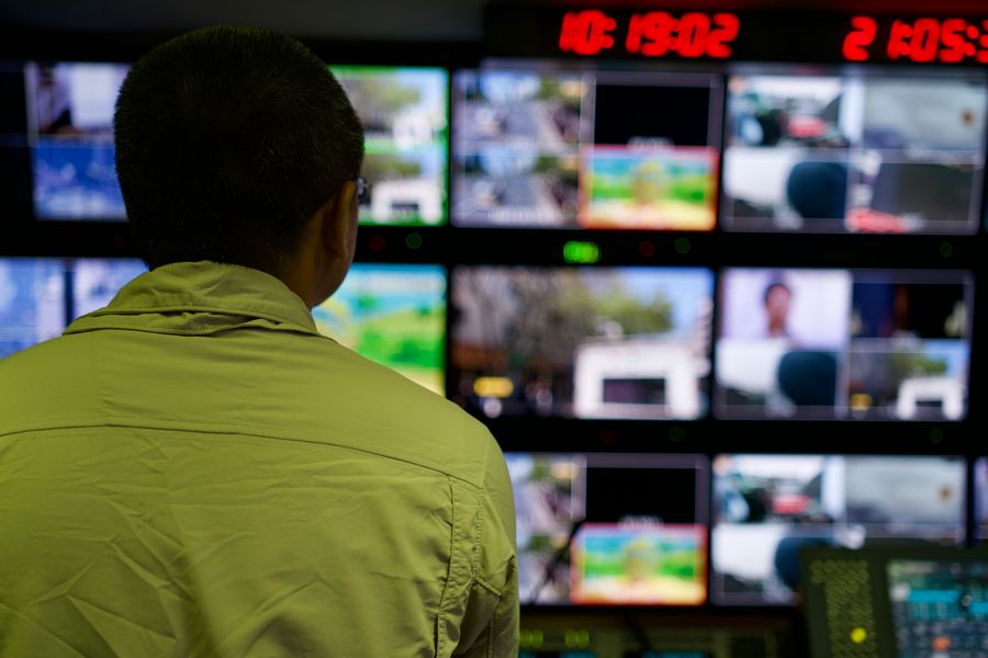 Operador monitorando múltiplas telas com dashboards de rede